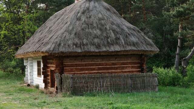 Drewniana chałupa kryta strzechą w skansenie w Tokarni